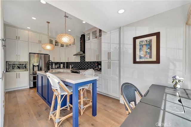 19325 Peachtree Ln, Huntington Beach, CA 92648 - kitchen featuring stainless steel appliances, wall chimney exhaust hood, light countertops, backsplash, and glass insert cabinets