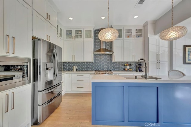 19325 Peachtree Ln, Huntington Beach, CA 92648 - kitchen with appliances with stainless steel finishes, light countertops, pendant lighting, light wood finished floors, and tasteful backsplash