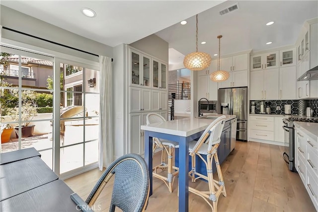19325 Peachtree Ln, Huntington Beach, CA 92648 - kitchen with stainless steel appliances, decorative backsplash, white cabinets, and recessed lighting