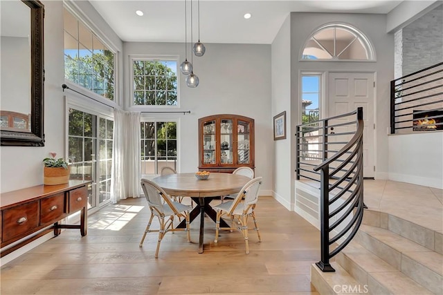 19325 Peachtree Ln, Huntington Beach, CA 92648 - dining area featuring a towering ceiling, light wood-style floors, recessed lighting, and stairway