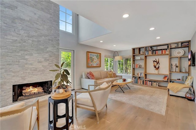 19325 Peachtree Ln, Huntington Beach, CA 92648 - living room featuring healthy amount of natural light, wood finished floors, a fireplace, recessed lighting, and a high ceiling