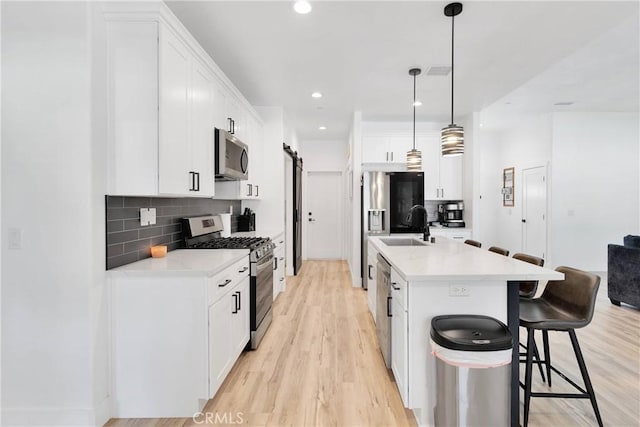 12207 Snapping Turtle Rd, Apple Valley, CA 92308 - kitchen with stainless steel appliances, a breakfast bar area, tasteful backsplash, light wood-style floors, and recessed lighting