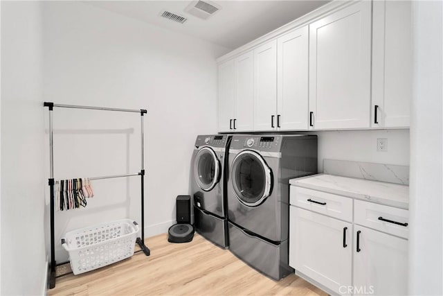 12207 Snapping Turtle Rd, Apple Valley, CA 92308 - laundry room featuring cabinet space, separate washer and dryer, and light wood-type flooring