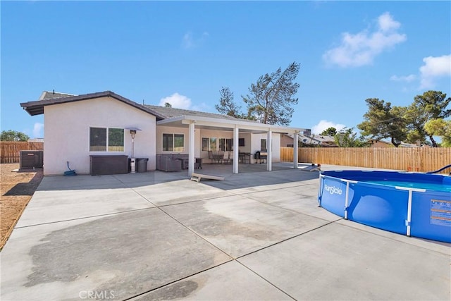 12207 Snapping Turtle Rd, Apple Valley, CA 92308 - back of house featuring a fenced backyard, stucco siding, a patio area, and an outdoor living space
