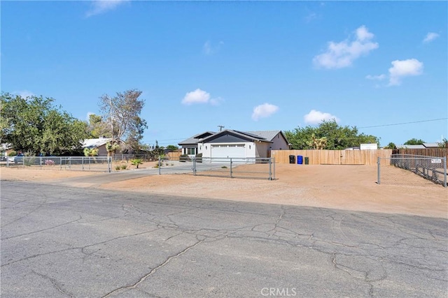 12207 Snapping Turtle Rd, Apple Valley, CA 92308 - view of front of home with roof mounted solar panels, a garage, a gate, and concrete driveway