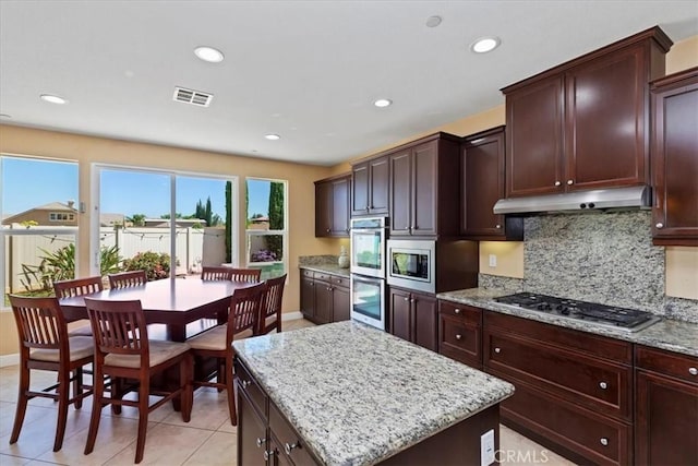 16858 Mariposa Ave, Riverside, CA 92504 - kitchen featuring appliances with stainless steel finishes, under cabinet range hood, tasteful backsplash, recessed lighting, and light stone countertops