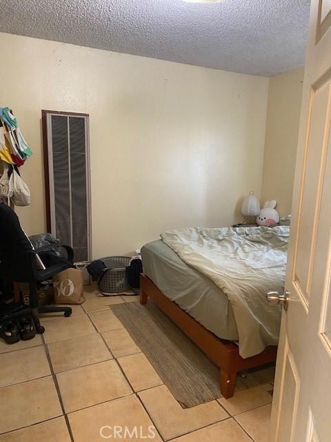 831 Alamitos Ave Unit 3, Long Beach, CA 90813 - bedroom with a textured ceiling and light tile patterned floors