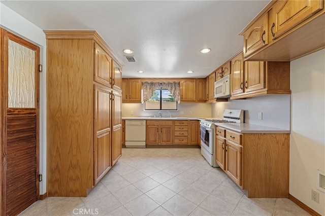 8038 Cyclamen Way, Buena Park, CA 90620 - kitchen with white appliances, light countertops, recessed lighting, light tile patterned floors, and brown cabinetry