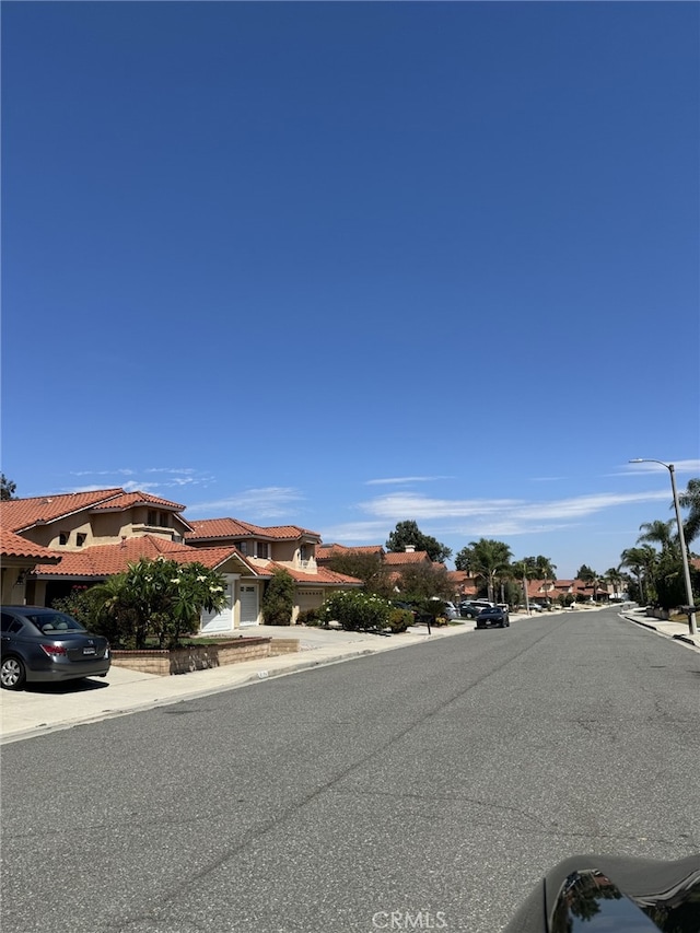 6159 Fleetwood Ln, Chino Hills, CA 91709 - view of asphalt road featuring curbs, street lighting, sidewalks, and a residential view