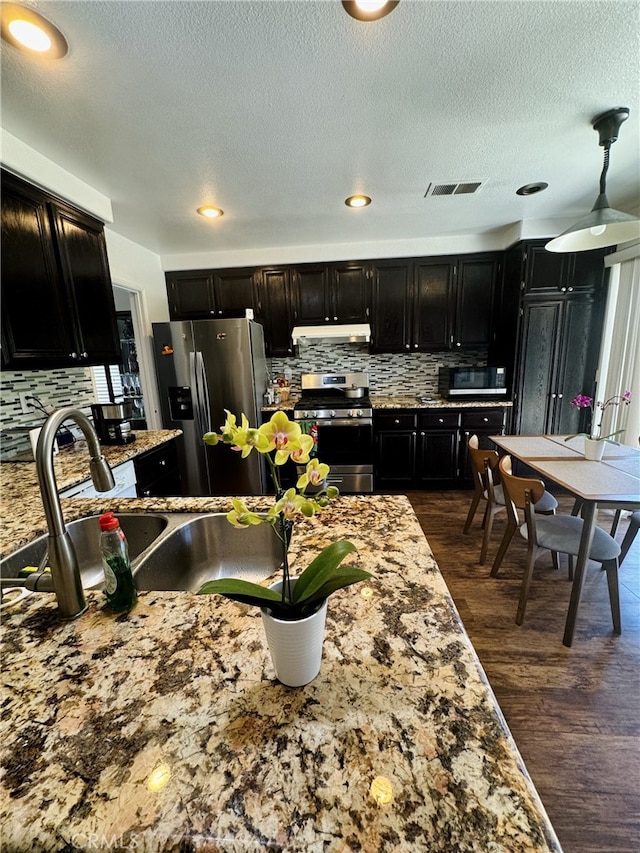 6159 Fleetwood Ln, Chino Hills, CA 91709 - kitchen featuring stainless steel appliances, under cabinet range hood, dark cabinetry, decorative backsplash, and dark wood-type flooring