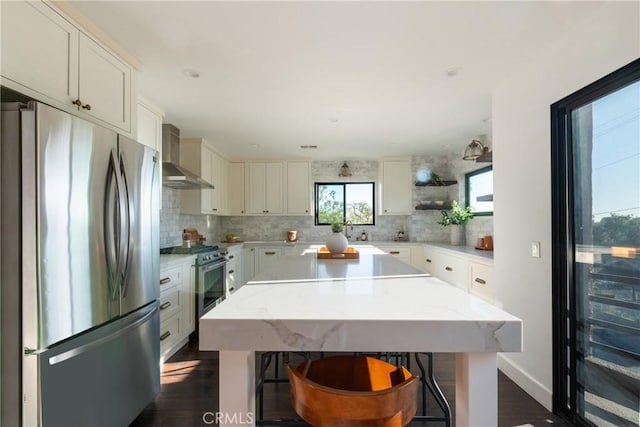 1830 N Alvarado St Unit 14, Los Angeles, CA 90026 - kitchen featuring appliances with stainless steel finishes, wall chimney range hood, backsplash, and a kitchen island