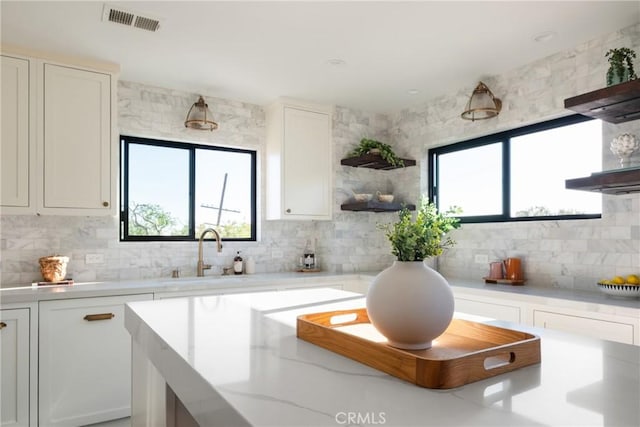 1830 N Alvarado St Unit 14, Los Angeles, CA 90026 - kitchen featuring tasteful backsplash, open shelves, healthy amount of natural light, and white cabinets