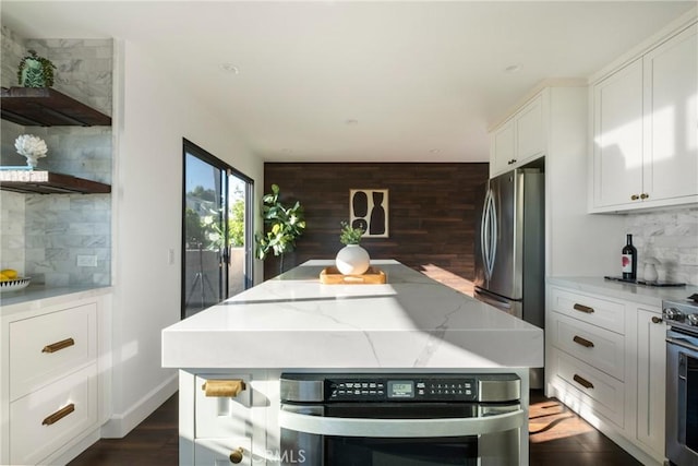 1830 N Alvarado St Unit 14, Los Angeles, CA 90026 - kitchen with stainless steel appliances, tasteful backsplash, white cabinets, a kitchen island, and wooden walls
