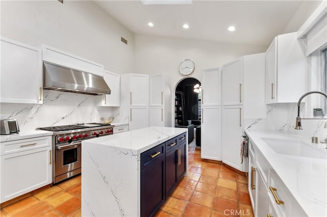 810 E Dalton Ave, Glendora, CA 91741 - kitchen with double oven range, extractor fan, tasteful backsplash, white cabinets, and arched walkways