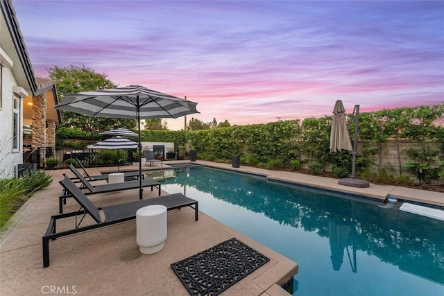 810 E Dalton Ave, Glendora, CA 91741 - pool at dusk featuring a fenced backyard, a patio, and a diving board