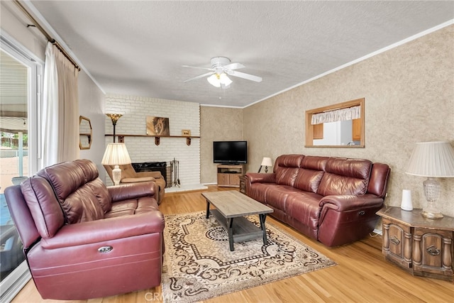 7219 Font Ave, Jurupa Valley, CA 92509 - living room featuring crown molding, wood finished floors, a ceiling fan, a textured ceiling, and a brick fireplace