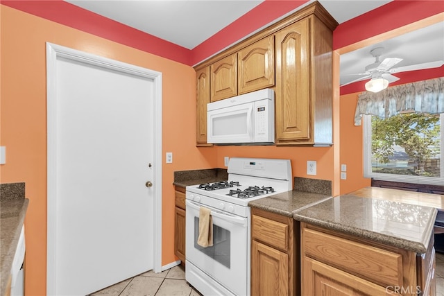 7219 Font Ave, Jurupa Valley, CA 92509 - kitchen with white appliances, light tile patterned floors, ceiling fan, and brown cabinetry