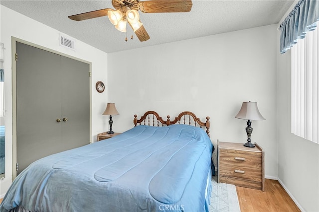 7219 Font Ave, Jurupa Valley, CA 92509 - bedroom with wood finished floors, a textured ceiling, a closet, and a ceiling fan