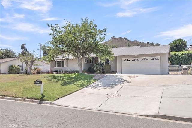 7219 Font Ave, Jurupa Valley, CA 92509 - view of front facade with driveway, stucco siding, a garage, and a gate