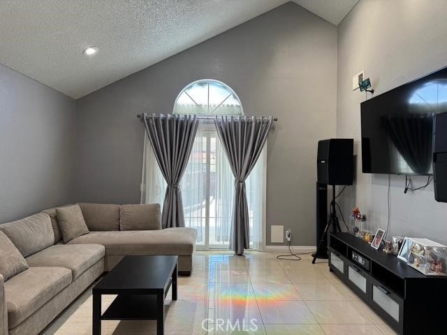 3629 Puente Ave, Baldwin Park, CA 91706 - living area with high vaulted ceiling, a textured ceiling, and light tile patterned floors
