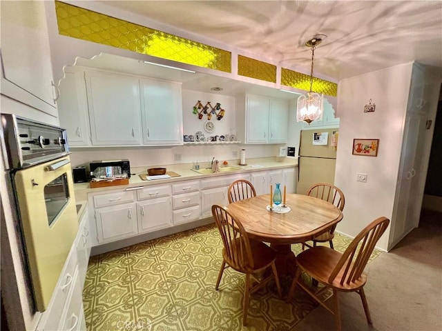 1660 Northwood Rd Unit M11-276D, Seal Beach, CA 90740 - kitchen with freestanding refrigerator, oven, white cabinetry, light countertops, and hanging light fixtures