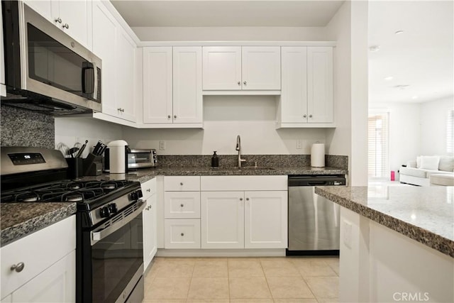 11624 Sky Pointe Dr, Desert Hot Springs, CA 92240 - kitchen with appliances with stainless steel finishes, dark stone countertops, white cabinetry, light tile patterned floors, and recessed lighting