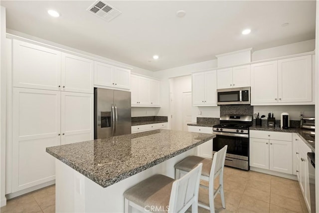 11624 Sky Pointe Dr, Desert Hot Springs, CA 92240 - kitchen featuring stainless steel appliances, a kitchen island, light tile patterned flooring, white cabinets, and recessed lighting