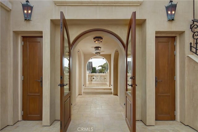 3300 Ocean Blvd, Corona Del Mar, CA 92625 - corridor with arched walkways, stone tile flooring, and french doors