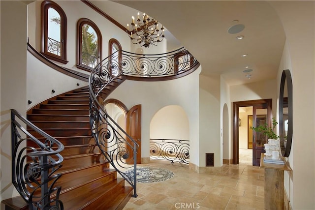 3300 Ocean Blvd, Corona Del Mar, CA 92625 - stairway featuring arched walkways, stone tile flooring, a high ceiling, a chandelier, and recessed lighting
