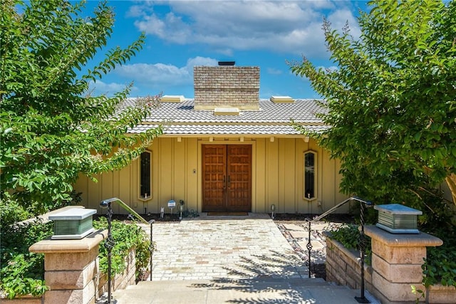 4308 Crown Ranch Rd, Corona, CA 92881 - view of front of home with board and batten siding, a tiled roof, and a chimney