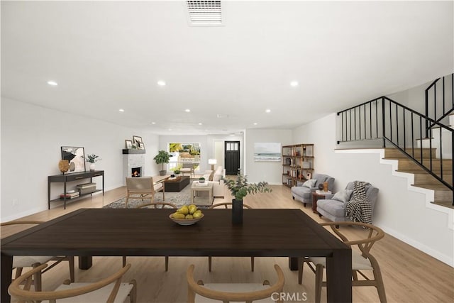 1604 W 125th St, Los Angeles, CA 90047 - dining area featuring light wood-style floors, stairs, recessed lighting, and a lit fireplace