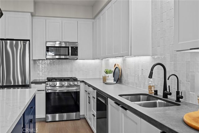 1652 W Sycamore Dr, Compton, CA 90220 - kitchen with stainless steel appliances, white cabinets, tasteful backsplash, and wood finished floors