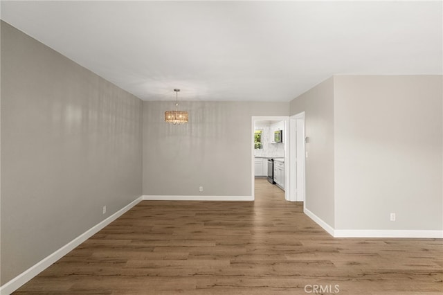 1575 Via Capri Unit 6, Laguna Beach, CA 92651 - spare room with a chandelier and light wood-type flooring