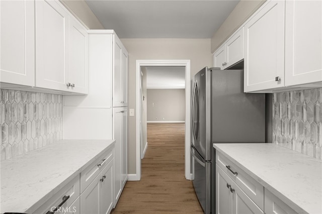1575 Via Capri Unit 6, Laguna Beach, CA 92651 - kitchen with freestanding refrigerator, white cabinetry, decorative backsplash, light wood-type flooring, and light stone countertops