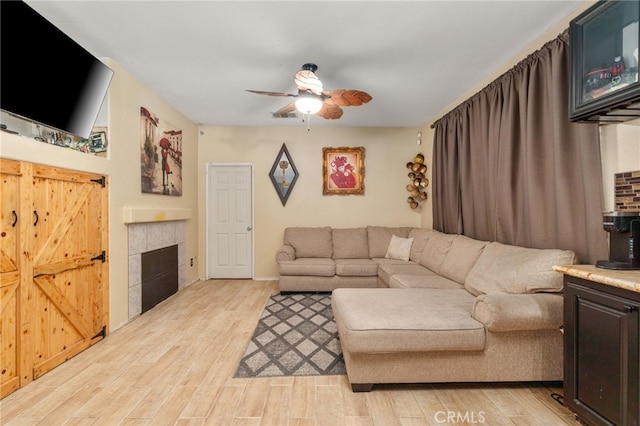 7459 Melanie Ct, Highland, CA 92346 - living area featuring a ceiling fan, light wood-style flooring, and a fireplace