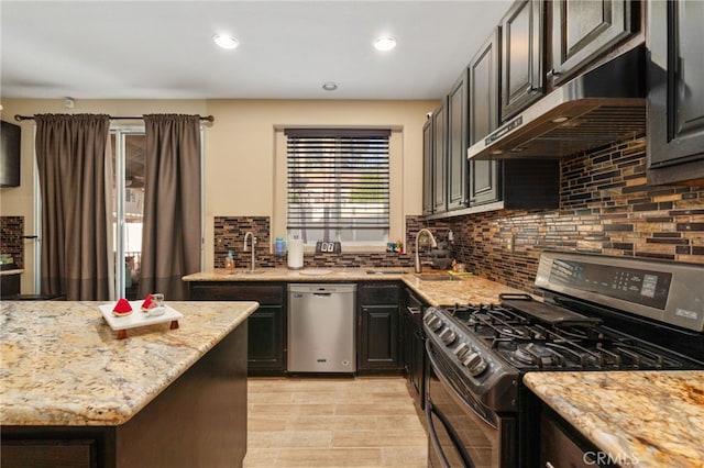 7459 Melanie Ct, Highland, CA 92346 - kitchen with range with gas stovetop, dishwasher, under cabinet range hood, light stone counters, and recessed lighting