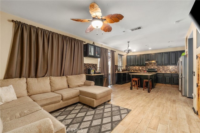 7459 Melanie Ct, Highland, CA 92346 - living area with light wood-style flooring, ceiling fan, recessed lighting, and a chandelier