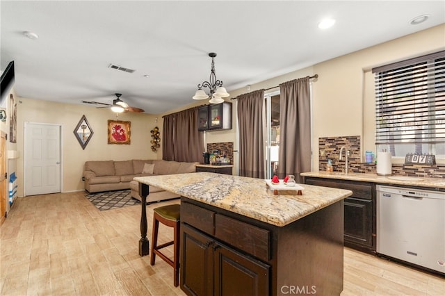 7459 Melanie Ct, Highland, CA 92346 - kitchen with stainless steel dishwasher, tasteful backsplash, light wood-type flooring, a center island, and a ceiling fan