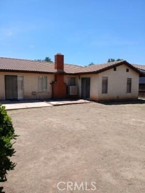 12936 Glenmere Dr, Moreno Valley, CA 92553 - rear view of property with stucco siding, a chimney, a tile roof, and a patio area
