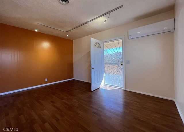 583 S Calle, Abronia, Palm Springs, CA 92264 - spare room featuring a wall mounted AC, wood finished floors, track lighting, attic access, and a textured ceiling