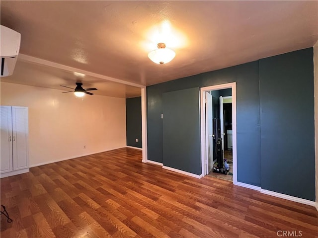 583 S Calle, Abronia, Palm Springs, CA 92264 - spare room featuring wood finished floors, an AC wall unit, and a ceiling fan
