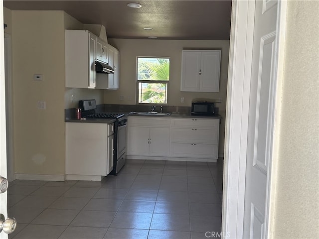 23610 David Ln, Moreno Valley, CA 92557 - kitchen with gas stove, under cabinet range hood, black microwave, white cabinetry, and recessed lighting