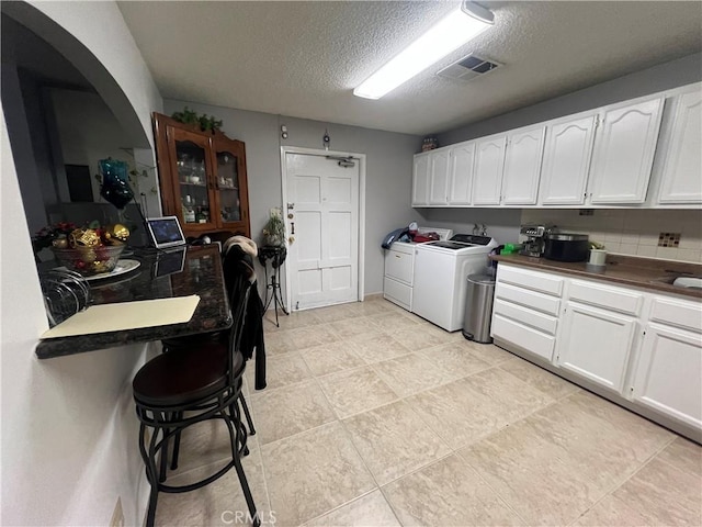 729 W Holt Blvd, Ontario, CA 91762 - laundry room with washing machine and clothes dryer, a textured ceiling, and arched walkways