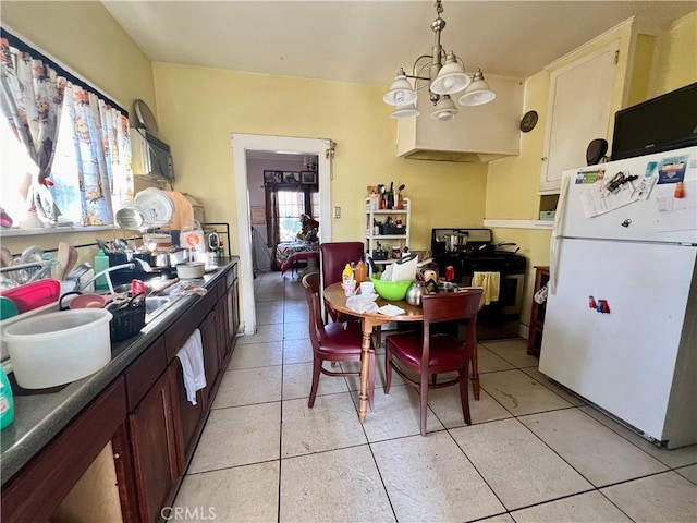 729 W Holt Blvd, Ontario, CA 91762 - kitchen with freestanding refrigerator, a chandelier, dark countertops, light tile patterned flooring, and range