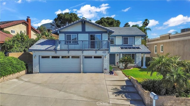 1010 W Yorktown Ave, Montebello, CA 90640 - view of front of home with concrete driveway, stucco siding, a balcony, an attached garage, and a tile roof