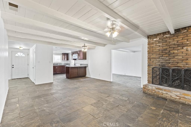 5956 Marlatt St, Jurupa Valley, CA 91752 - unfurnished living room with ceiling fan, stone tile floors, a fireplace, and beamed ceiling