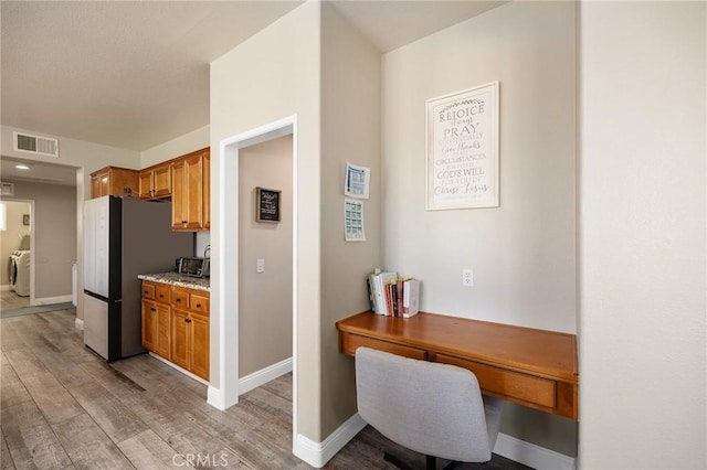 33883 Vinca Ln, Murrieta, CA 92563 - kitchen with freestanding refrigerator, light wood-type flooring, and brown cabinetry