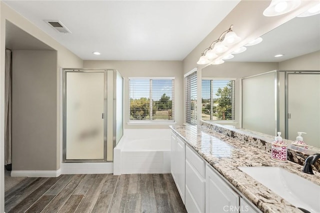 33883 Vinca Ln, Murrieta, CA 92563 - full bathroom featuring double vanity, a stall shower, a bath, wood finished floors, and recessed lighting