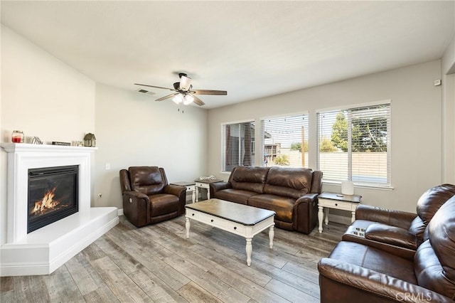 33883 Vinca Ln, Murrieta, CA 92563 - living area with light wood-style floors, ceiling fan, and a glass covered fireplace