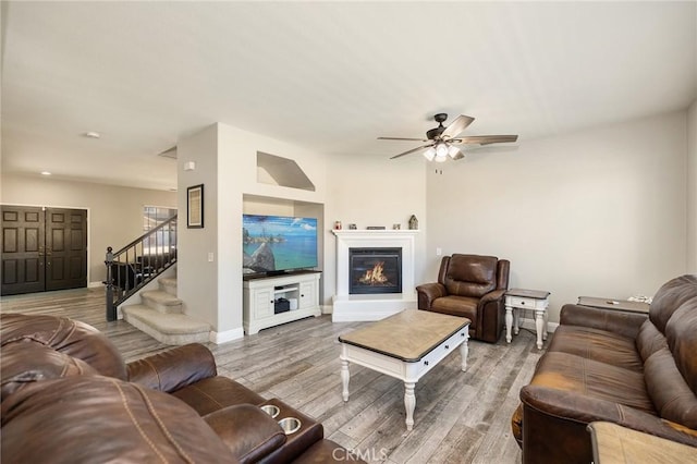 33883 Vinca Ln, Murrieta, CA 92563 - living area with stairs, a ceiling fan, light wood finished floors, and a glass covered fireplace